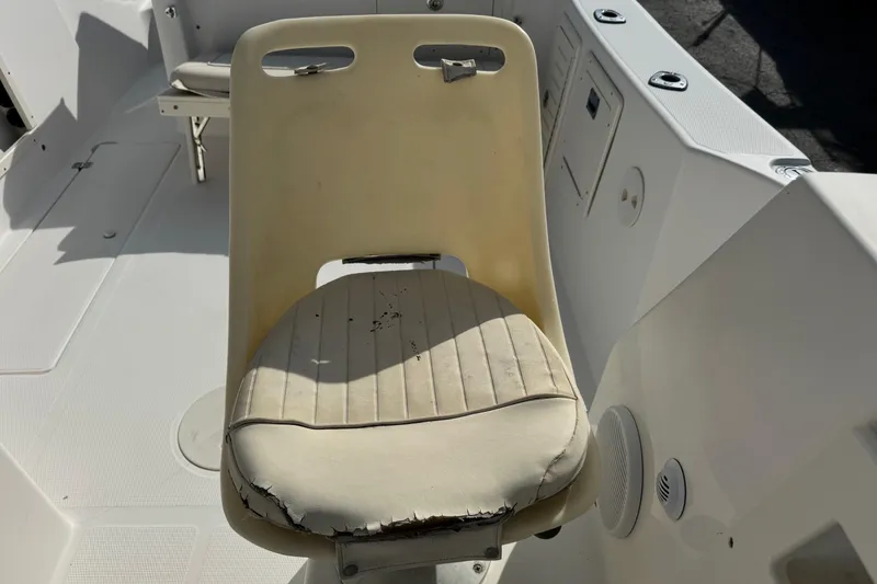 Slide: The Image of Worn seat on 2006 Mako 253 Walk Around boat, showing visible damage and aging. - 17