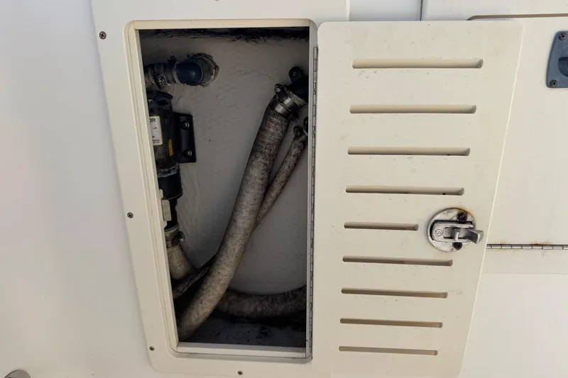 Slide: The Image of Boat compartment with hoses and pump, Mako 253 Walk Around, 2006 model. - 22