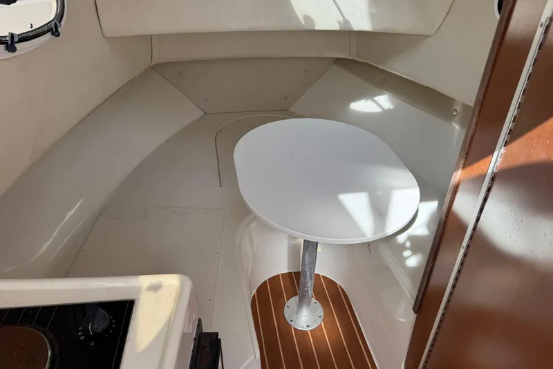 Slide: The Image of Interior of 2006 Mako 253 Walk Around boat with table and seating area. - 24