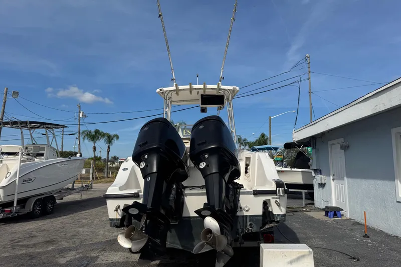 Slide: The Image of 2006 Mako 253 Walk Around boat with dual outboard motors in a marina setting. - 3