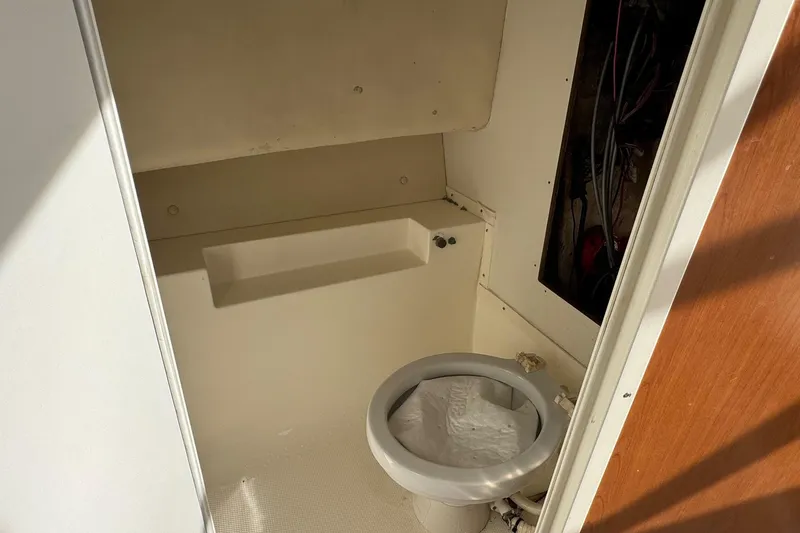 Slide: The Image of 2006 Mako 253 Walk Around boat interior with compact marine toilet. - 30