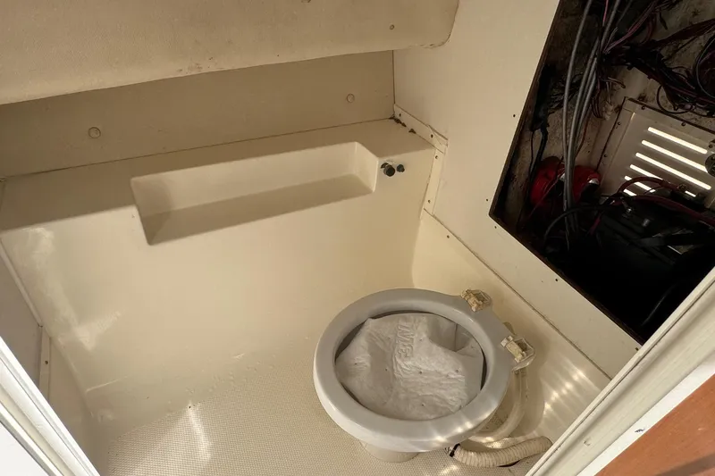 Slide: The Image of 2006 Mako 253 Walk Around boat interior with toilet and wiring compartment. - 33