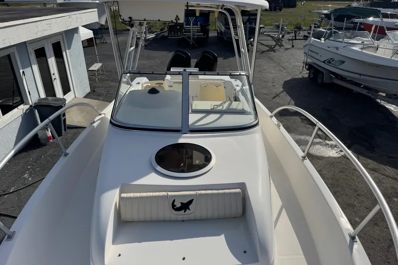 Slide: The Image of 2006 Mako 253 Walk Around boat, white exterior, docked at marina with other boats. - 36