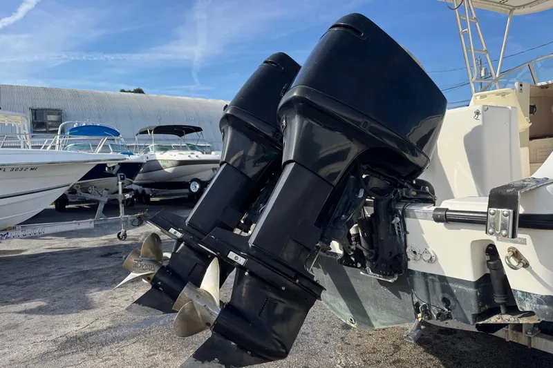 Slide: The Image of Twin outboard motors on a 2006 Mako 253 Walk Around boat in a marina. - 40
