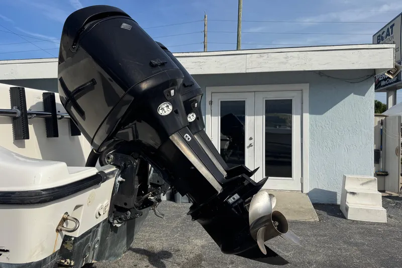 Slide: The Image of Outboard motor on a 2006 Mako 253 Walk Around boat, parked near a building. - 41