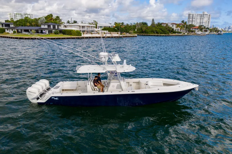The Image of 2017 SeaVee 390Z boat cruising on a scenic waterway with waterfront homes. - 0