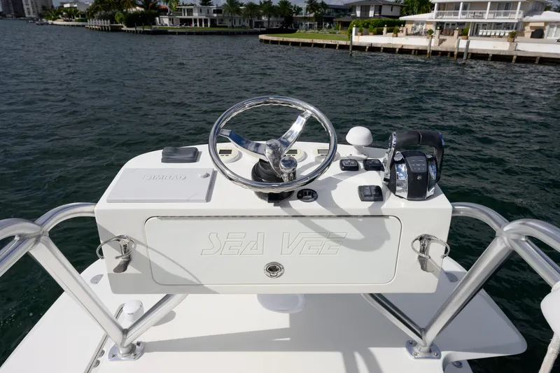 Slide: The Image of 2017 SeaVee 390Z boat helm with steering wheel and controls, dockside view. - 8