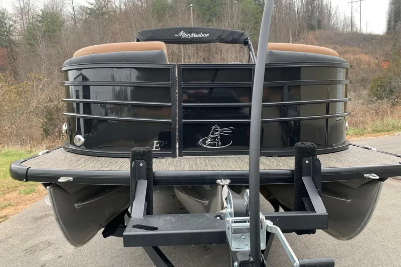 Slide: The Image of 2020 Misty Harbor Elite E3U pontoon boat on trailer, parked outdoors. - 2