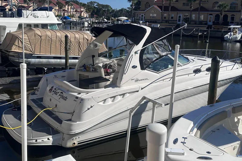 Slide: The Image of 2004 Sea Ray 320 Sundancer docked at marina, sleek design, calm water reflection. - 2