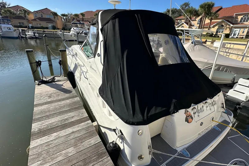 Slide: The Image of 2004 Sea Ray 320 Sundancer docked at marina with black canvas cover. - 21