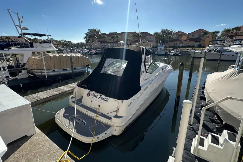 Slide: The Image of 2004 Sea Ray 320 Sundancer docked in a sunny marina, surrounded by other boats. - 23