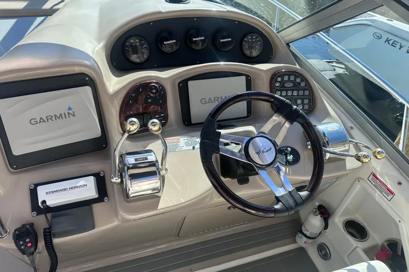 Slide: The Image of 2004 Sea Ray 320 Sundancer docked at a marina, featuring sleek design and spacious deck. - 4