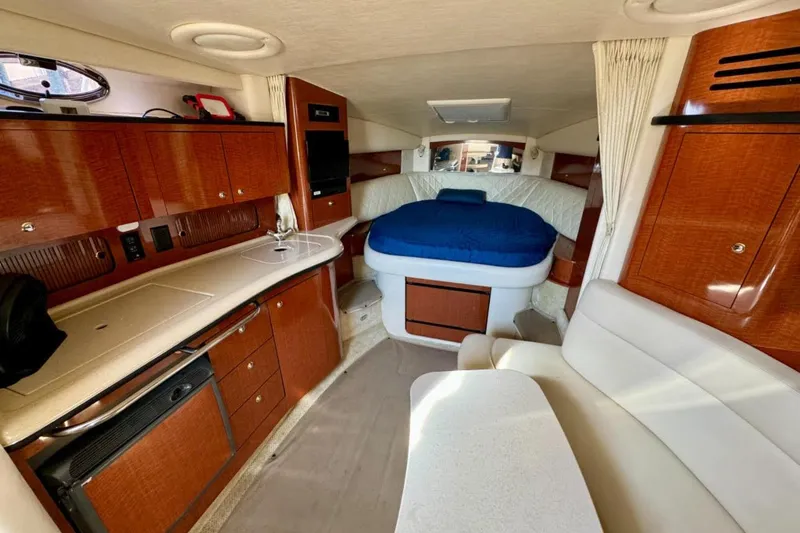 Slide: The Image of 2004 Sea Ray 320 Sundancer interior with seating, table, and kitchenette. - 8