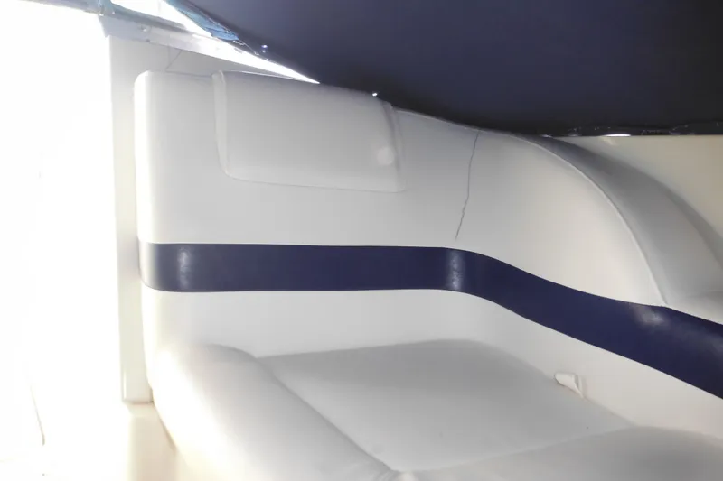 Slide: The Image of Interior seating of a 2003 Formula 280 Bowrider boat, featuring white and blue upholstery. - 32