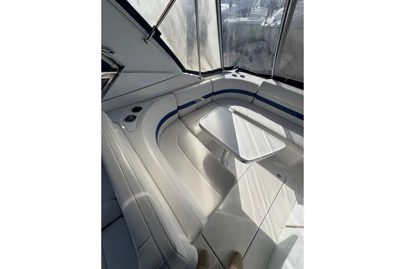 Slide: The Image of Interior of 2003 Formula 280 Bowrider with white seating and table, enclosed by windows. - 51