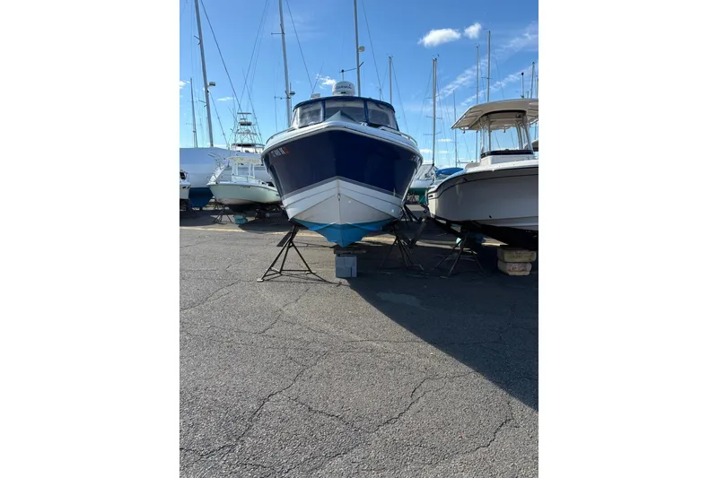 Slide: The Image of 2003 Formula 280 Bowrider boat on stands in a marina, surrounded by other vessels. - 71