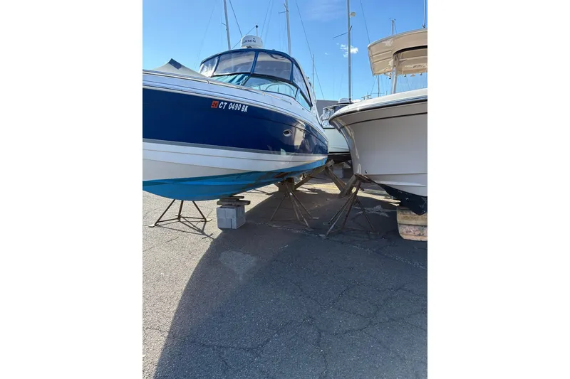 Slide: The Image of 2003 Formula 280 Bowrider boat on stands, parked outdoors under clear blue sky. - 72