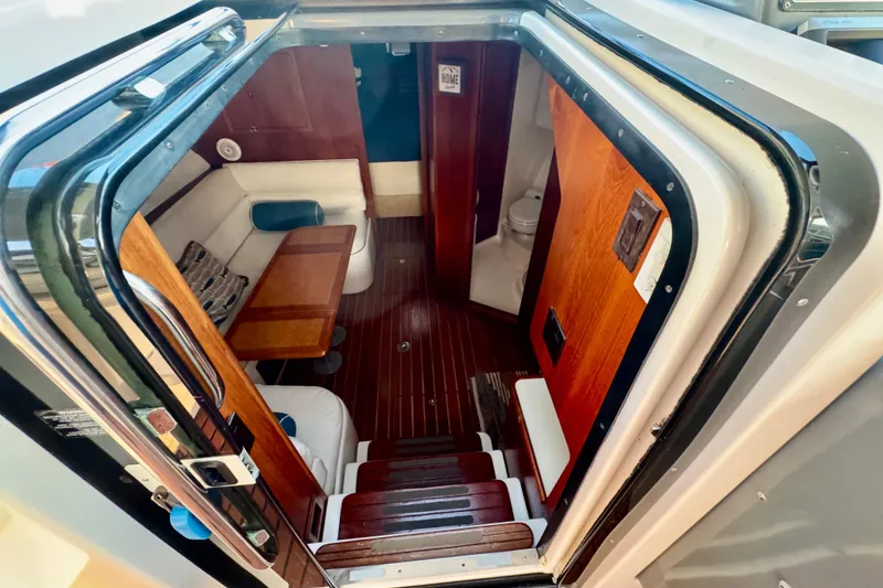 Slide: The Image of 2000 Tiara 37 Open yacht kitchen with sink, microwave, and wooden cabinets. - 29