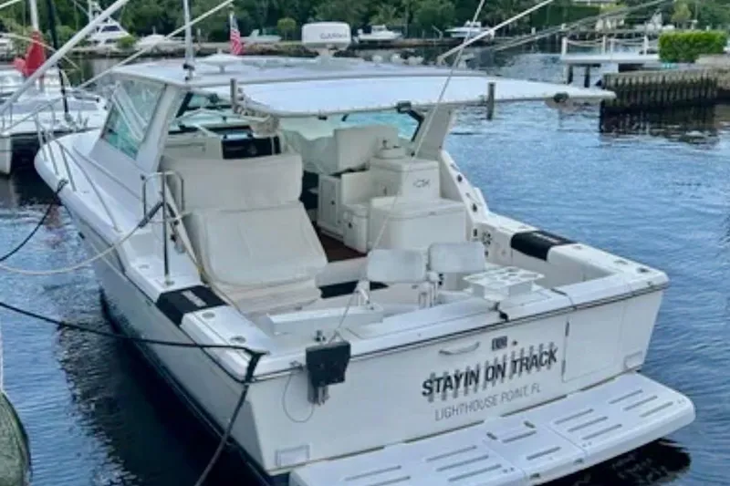 Slide: The Image of 2000 Tiara 37 Open yacht interior with white seating and helm, docked by the water. - 6