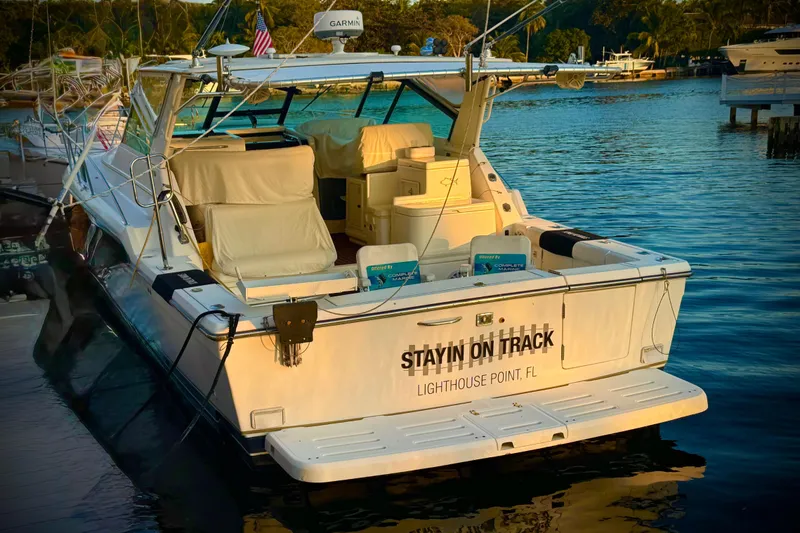 Slide: The Image of Interior of 2000 Tiara 37 Open yacht with seating and helm, docked by water. - 87