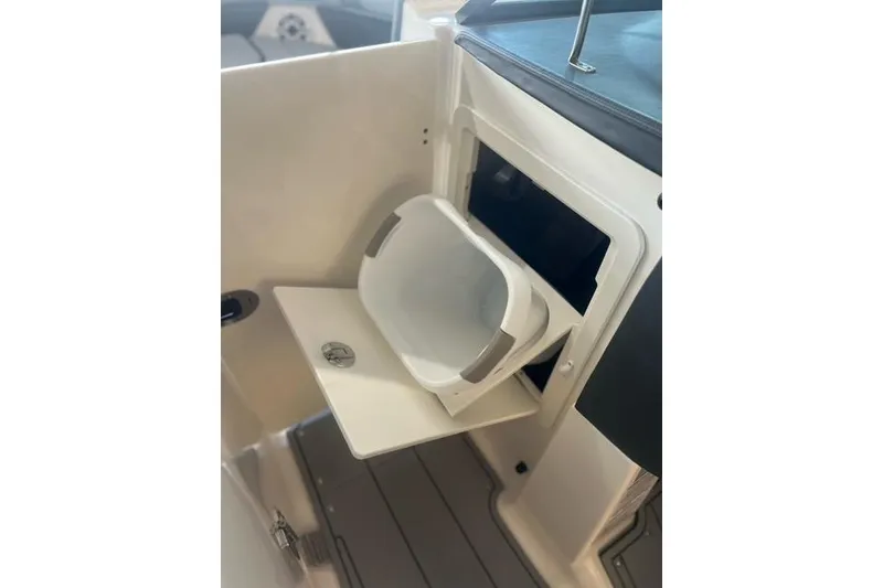 Slide: The Image of 2025 Chaparral 267 SSX boat interior with built-in trash receptacle. - 12