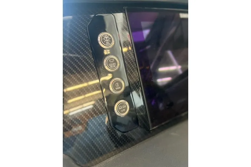 Slide: The Image of Carbon fiber dashboard with control buttons on 2025 Chaparral 267 SSX boat. - 26