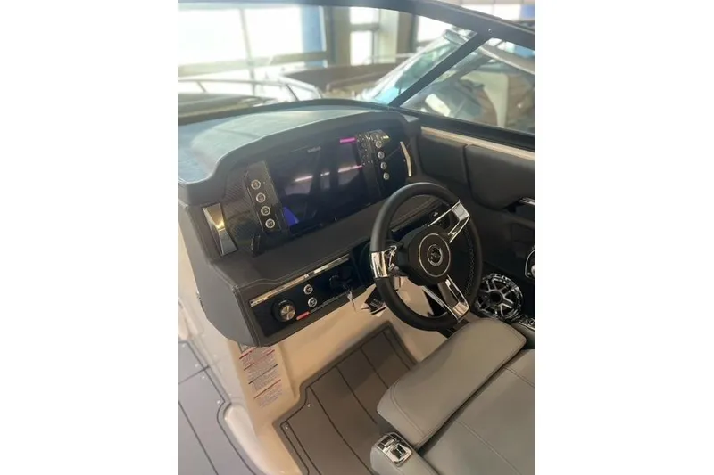Slide: The Image of 2025 Chaparral 267 SSX boat dashboard with modern steering and controls. - 29