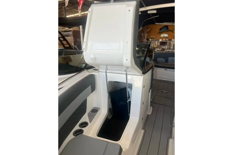 Slide: The Image of 2025 Chaparral 267 SSX boat interior with open storage compartment and seating area. - 8