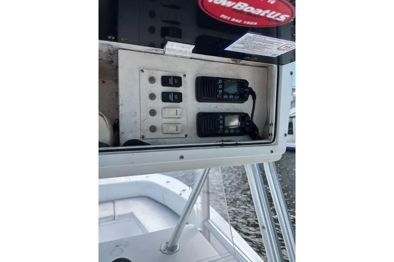 Slide: The Image of 2006 Dusky 278 boat cockpit with steering wheel and navigation equipment, surrounded by tropical foliage. - 16