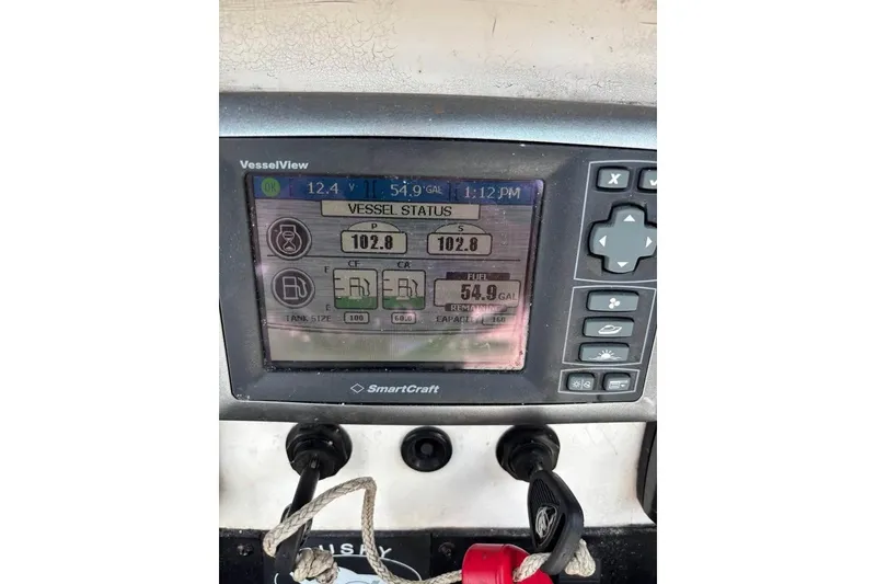 Slide: The Image of 2006 Dusky 278 boat console with radios and controls, featuring Fusion and TowBoat U.S. stickers. - 18