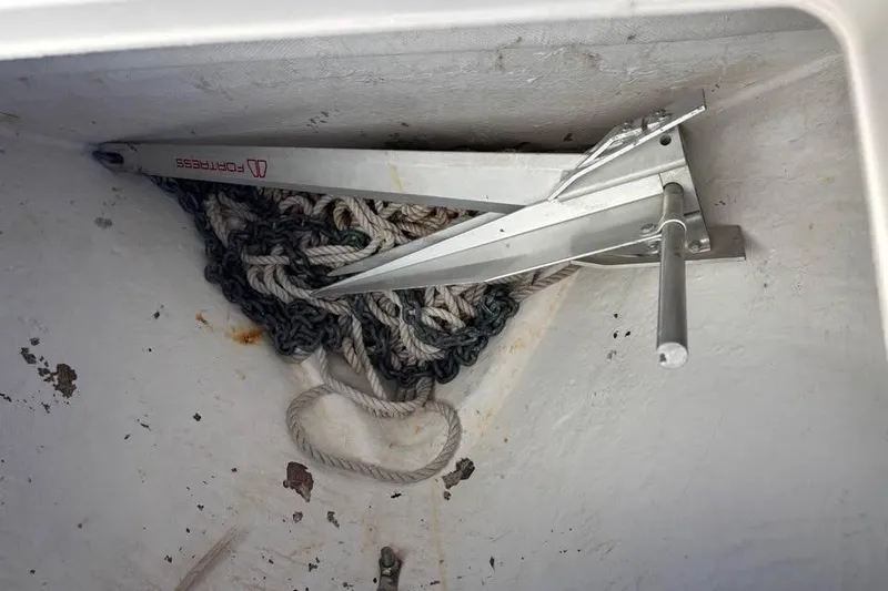 Slide: The Image of 2006 Dusky 278 boat interior with open storage compartments, surrounded by greenery. - 29