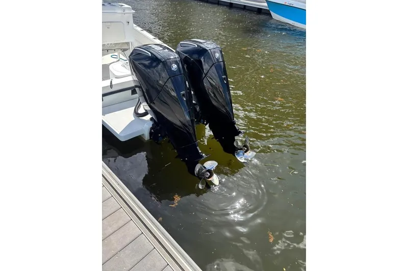 Slide: The Image of 2006 Dusky 278 boat interior with console, surrounded by lush greenery. - 4