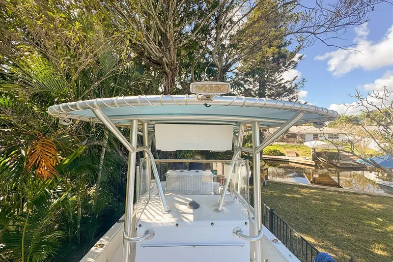 Slide: The Image of 2006 Dusky 278 boat with T-top, surrounded by lush greenery and clear blue sky. - 45