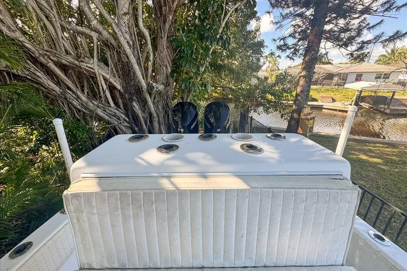 Slide: The Image of 2006 Dusky 278 boat with seating and rod holders, near lush trees and a canal. - 48