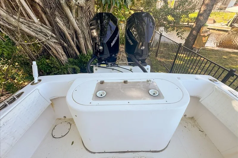 Slide: The Image of 2006 Dusky 278 boat with dual Mercury outboard engines, docked near lush greenery. - 50