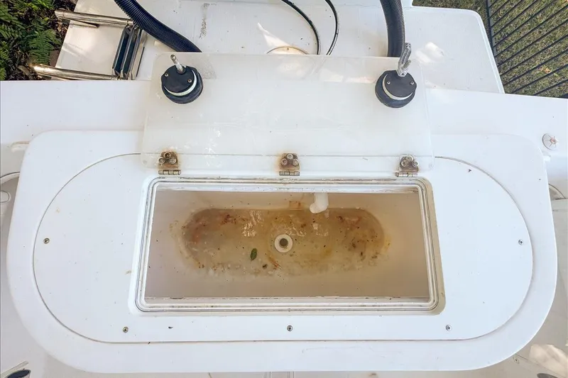 Slide: The Image of Livewell on a 2006 Dusky 278 boat, featuring dual hoses and a transparent lid. - 52