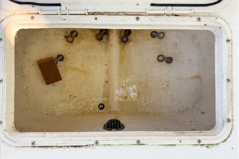 Slide: The Image of Open storage compartment of 2006 Dusky 278 boat with sponge and hooks inside. - 54