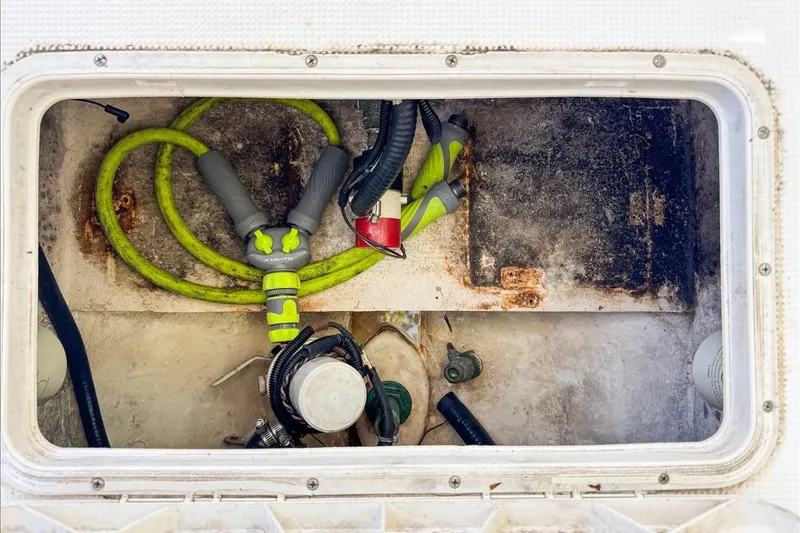 Slide: The Image of Storage compartment of a 2006 Dusky 278 boat with hoses and equipment. - 55