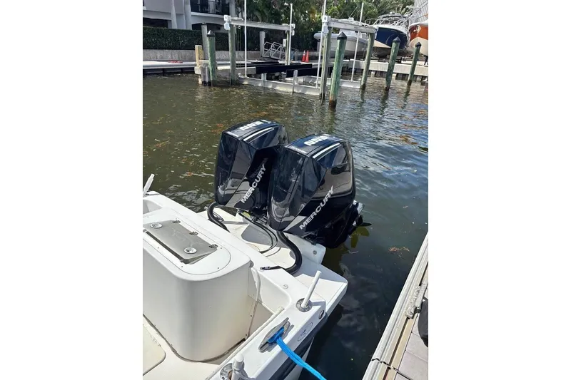 Slide: The Image of 2006 Dusky 278 boat cockpit with steering wheel and rod holders, surrounded by greenery. - 6