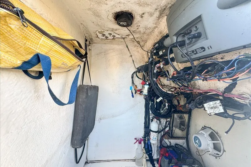 Slide: The Image of Interior of a 2006 Dusky 278 boat showing wiring and equipment storage. - 60