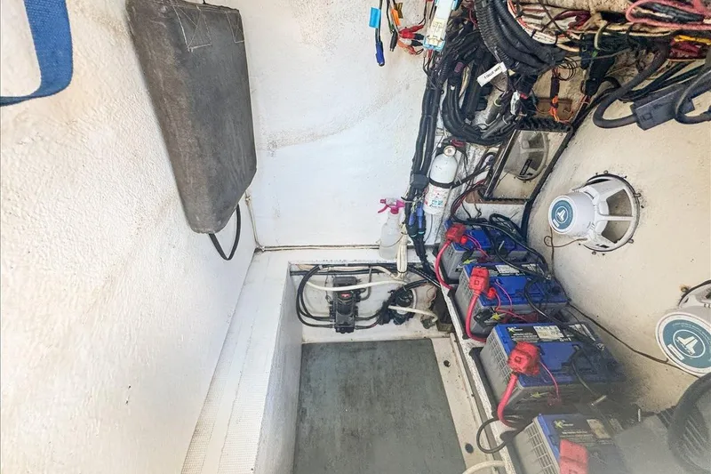 Slide: The Image of Electrical compartment of a 2006 Dusky 278 boat with batteries and wiring. - 61