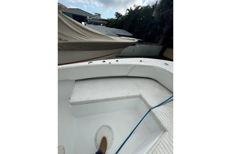 Slide: The Image of 2006 Dusky 278 boat interior with white seating and storage compartments. - 24