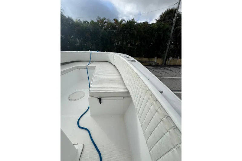 Slide: The Image of 2006 Dusky 278 boat interior with white cushioned seating and storage compartments. - 25