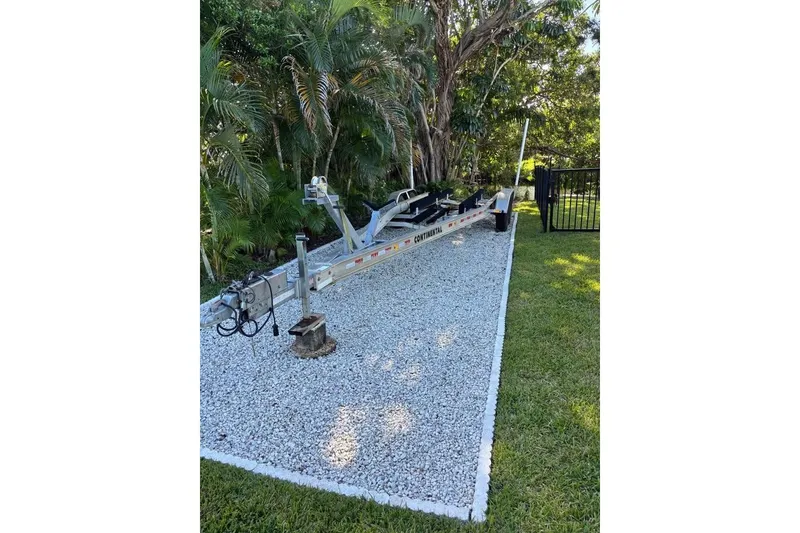 Slide: The Image of Dusky 278 boat (2006) parked in a residential backyard, surrounded by trees and houses. - 28