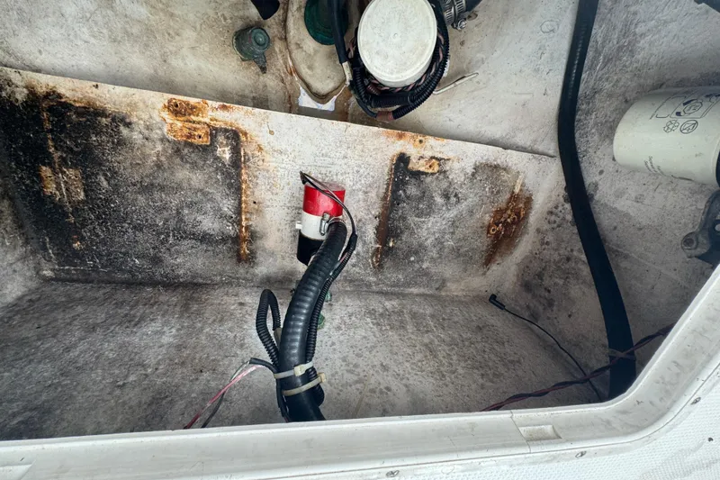 Slide: The Image of 2006 Dusky 278 boat deck, white with storage compartments, surrounded by greenery. - 36