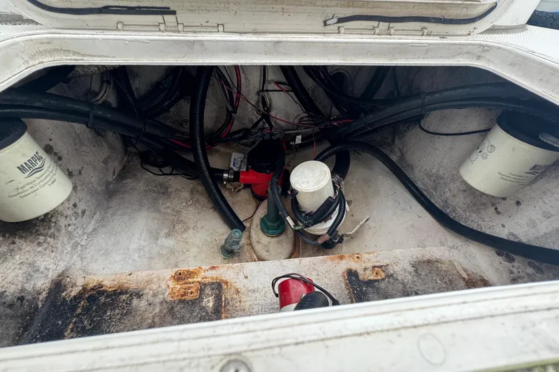 Slide: The Image of 2006 Dusky 278 boat interior with seating and storage, surrounded by lush greenery. - 37