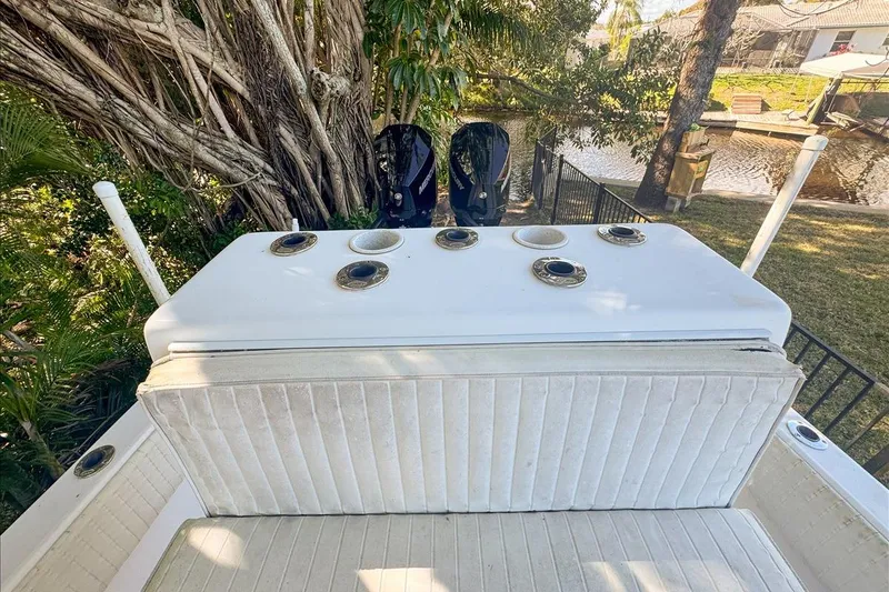 Slide: The Image of 2006 Dusky 278 boat with seating and rod holders, near a canal and lush greenery. - 47