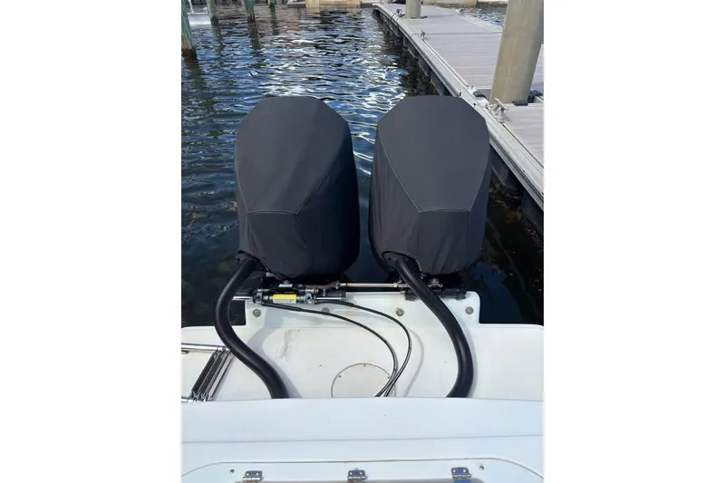 Slide: The Image of 2006 Dusky 278 boat with fishing rod holders, surrounded by lush greenery. - 5