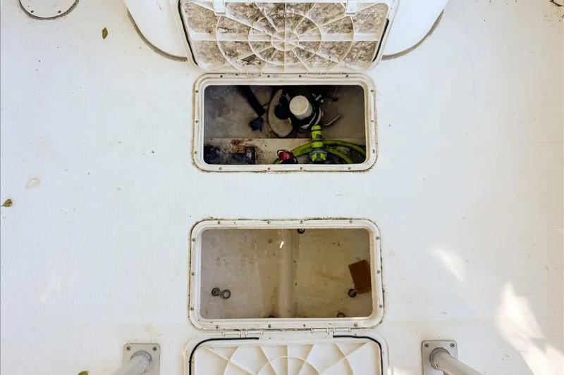 Slide: The Image of 2006 Dusky 278 boat deck with open storage compartments and visible equipment. - 53