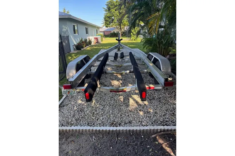 Slide: The Image of Boat trailer parked on gravel, surrounded by greenery, for Dusky 256, 2006 model. - 66